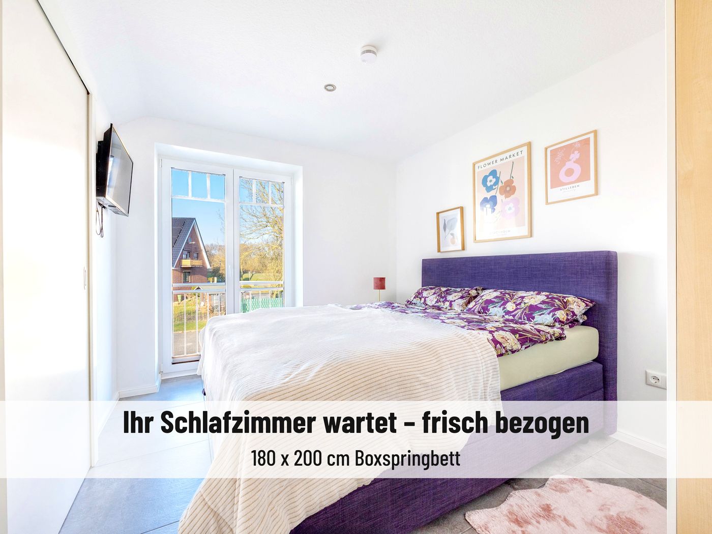Schlafzimmer mit Boxspringbett 180 mal 200 Zentimeter und Fenster ins Grüne